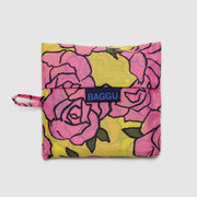 A standard Baggu reusable bag in the Rose design folded in its sleeve