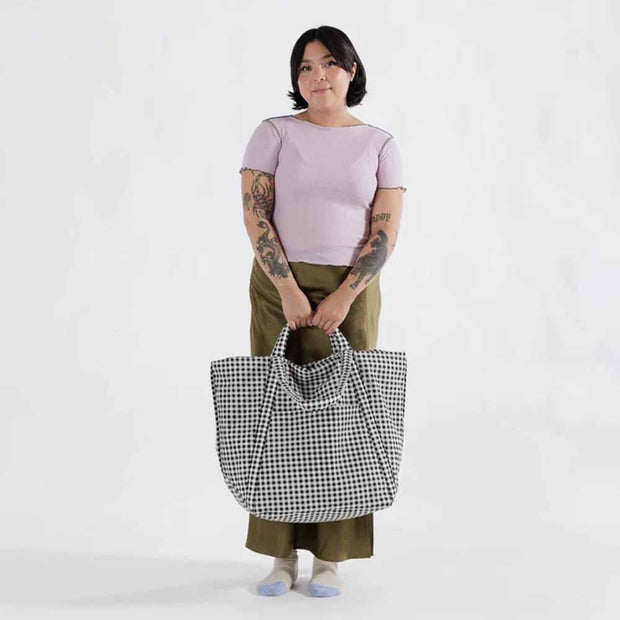 Person holding a Baggu Travel Cloud Bag in Black & White Gingham
