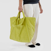 Person holding Baggu Travel Cloud bag in Lemongrass in their hand