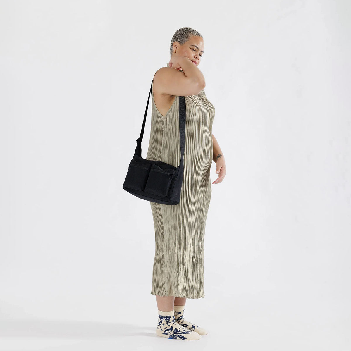 A person holding A black Baggu Medium Cargo Crossbody over her shoulder