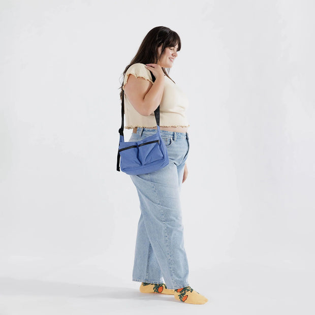 A person holding a Pansy Blue Medium Cargo Crossbody from Baggu