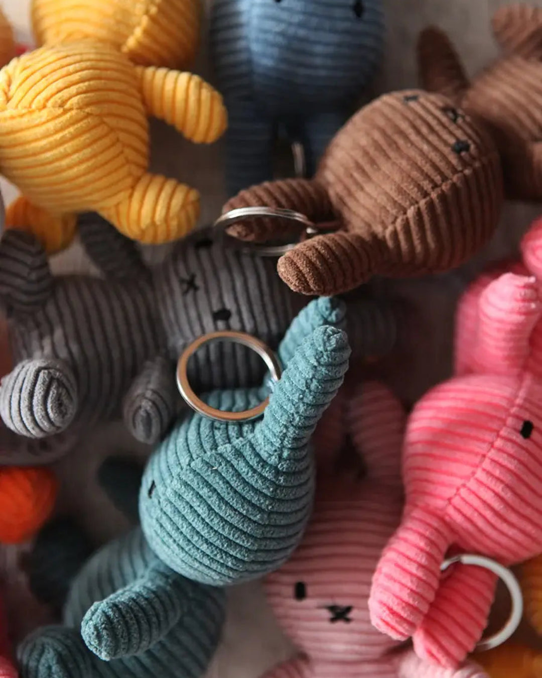 Collection of colorful Miffy plush keychains on a white background