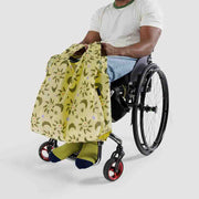Wheelchair user holding a standard Baggu in Sun and Moon Charms desig