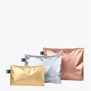 A set of LOQI Metallic Zip Pockets in gold, silver and rose gold